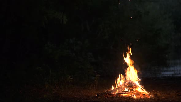 Bright yellow bonfire burning at night.