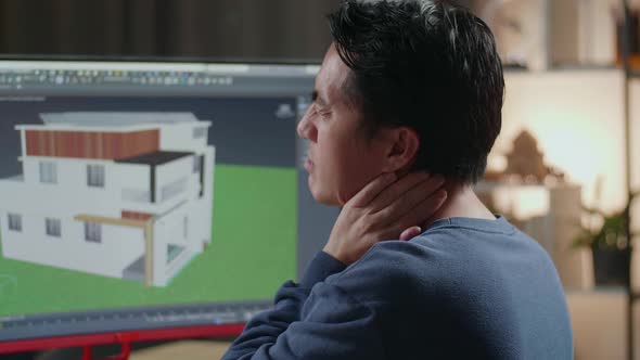 Close Up Of Asian Male Engineer Having A Neckache While Designing House On A Desktop At Home