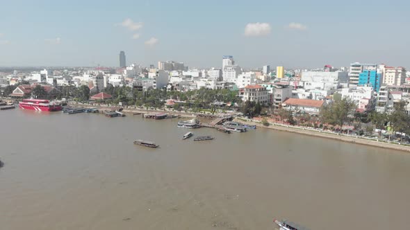 Aerial: Can Tho city skyline bridges over Mekong River, pedestrian walkaway waterfront skyscraper, M