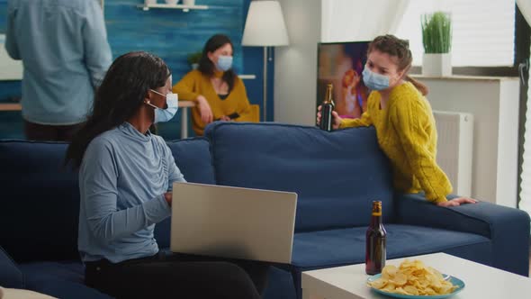 Happy Cheerful Woman Holding Beer Bottle Looking at Laptop