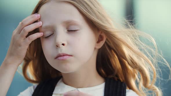 Head Shot of Little Sad Schoolgirl Child Standing on Street in Windy Weather, Feeling Sadness Grief