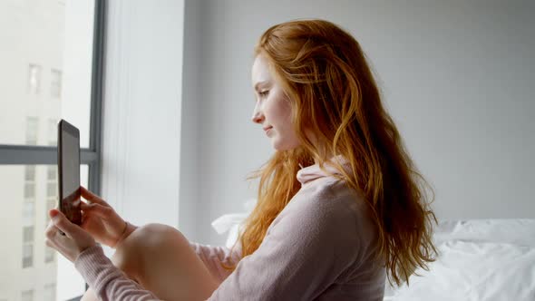 Woman using digital tablet in bedroom 4k