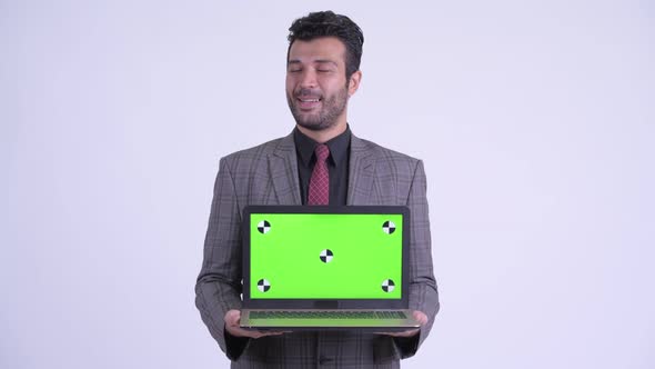 Happy Bearded Persian Businessman Thinking While Showing Laptop