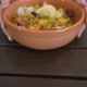 Woman Puts Orange Bowl with Shrimp Salad on Wooden Table - VideoHive Item for Sale