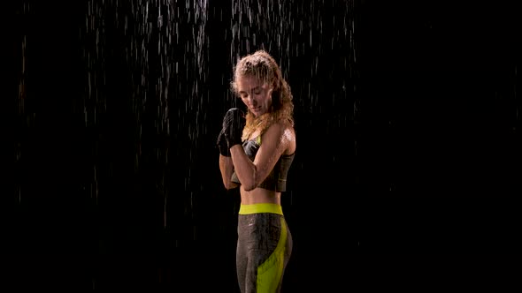 Sexy Woman in Green-gray Sports Top Is Standing in the Rain and Ready To Fight. Lady Boxer in Boxing