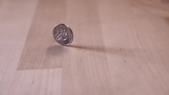 the coin is spinning on a wooden table