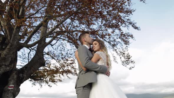 Lovely Young Newlyweds Bride Groom Embracing on Cloudy Sky Background Wedding Couple Family in Love