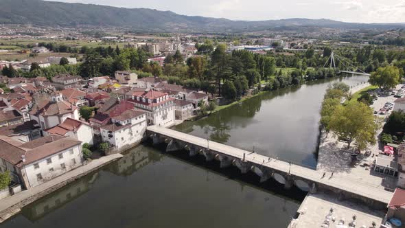 Aerial forward view of river with its Romanic bridge in city. Chaves. Portugal