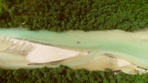 Aerial view of adventurers doing rafting surrounded by a big green forest.