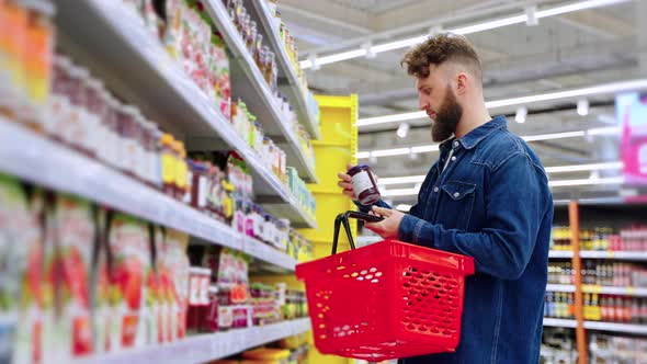 Male Visitor of Supermarket is Choosing Jam Taking Jar From Shelf