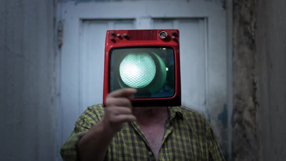 Man with Old TV on Head Showing a Green Traffic Light on Screen.