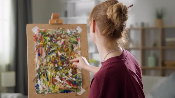 Young Woman Artist Draws a Picture with Oil Paints at Home in the Living Room
