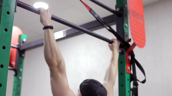 The Athlete Performs Exercises on the Crossbar