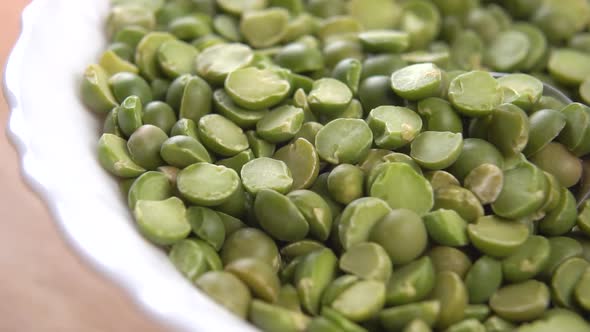 A full bowl of green split dry peas. Stirring in slow motion.