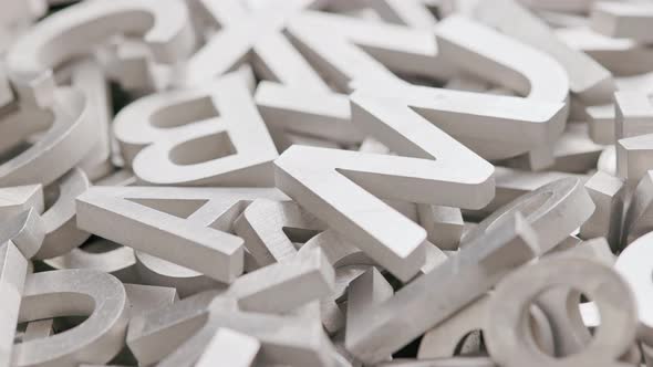 Full Frame Closeup Looped Slowly Rotating Background of Silver Metal Letters with Selective Focus