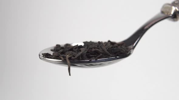 Healthy Tea Leaves Falling into a Shiny Teaspoon in Slow Motion