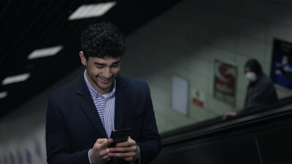 Positive Businessman Using Smartphone on Escalator