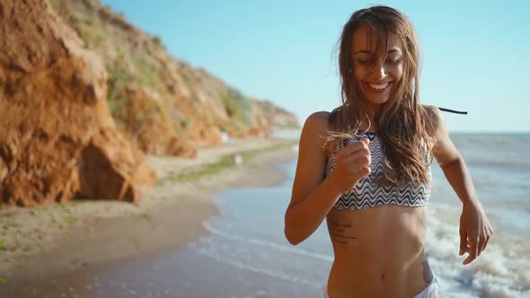 Slow Motion Footage of Happy Joyful Fitness Girl in Bikini Running Along Sand Sea Beach with High