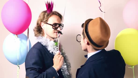 Cheerful male friends dancing in photo booth