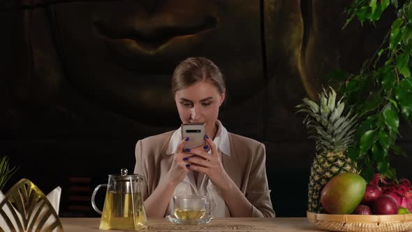 Cute Girl Takes a Photo of Tea on the Phone