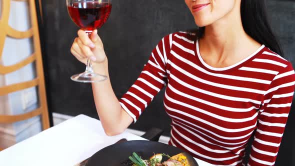 Smiling mature woman drinking red wine