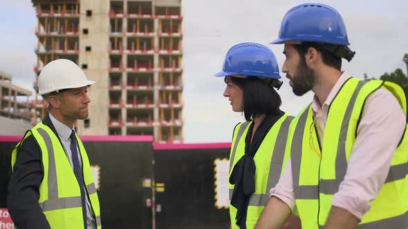 Men and woman discussing at construction site