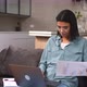 Positive Smart Young Multiracial Female Freelancer in Glasses Sitting on the Couch with Laptop - VideoHive Item for Sale
