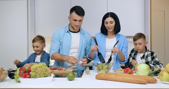 Young Parents and Their Children which Helping Each Other to Prepare Family Dinner