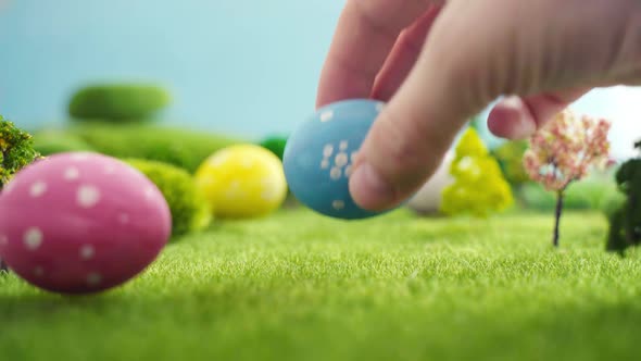 Hand Laying Easter Egg on Grass in Fairytale Fictional Macrocosm