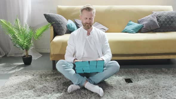 Man Working at the Computer with a Lot of Reminder Notes Sitting Near Sofa