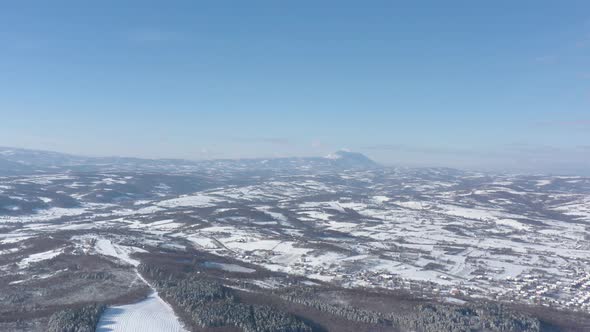 Rtanj mountain over the snowed valley 4K aerial video