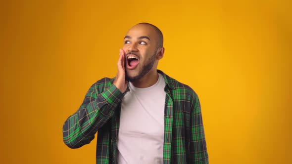 Happily Surprised and Shocked African American Man Against Yellow Background