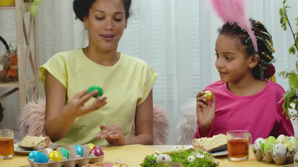 Mom and Daughter Have Fun and Break Easter Eggs