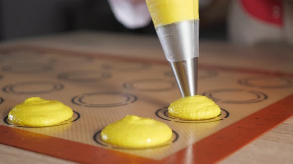 Pastry Chef Is Cooking Macaroons. Pouring Dough on Stencil Silicone Mat