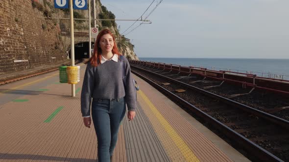 Beautiful Girl Walks to the Train Station Waiting Near the Sea