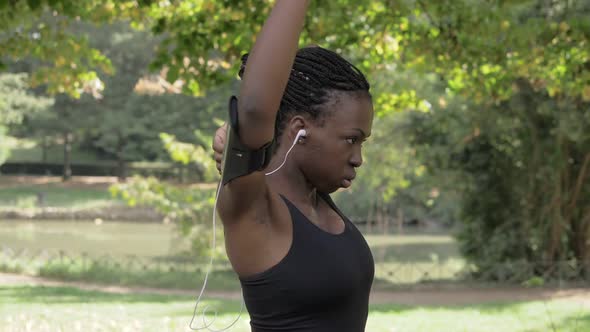 Doing stretching. African black woman doing stretching in the park-slow motion