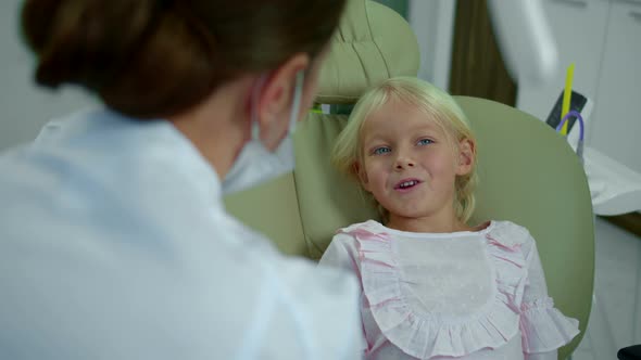 Little Girl Talks To Dentist and Points on Her Face and Mouth.