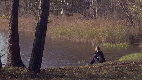 Lonely Girl Sitting at Lakeside Outdoors Thinking of Life Slow Motion Natural Daylight