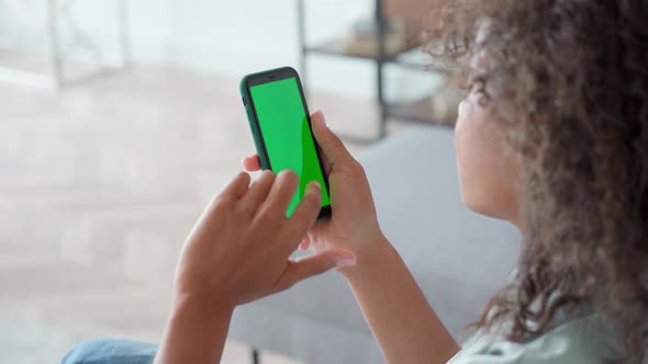 Afro American Girl Holding Cell Phone with Green Blank Empty Mockup Screen