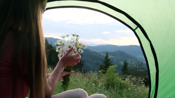 Beautiful Blonde Girl Sitting in a Tent She Holds Torn Flowers