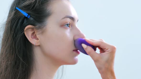 Hand of Professional Makeup Artist Applying Tonal Cream or Remedy Using Sponge