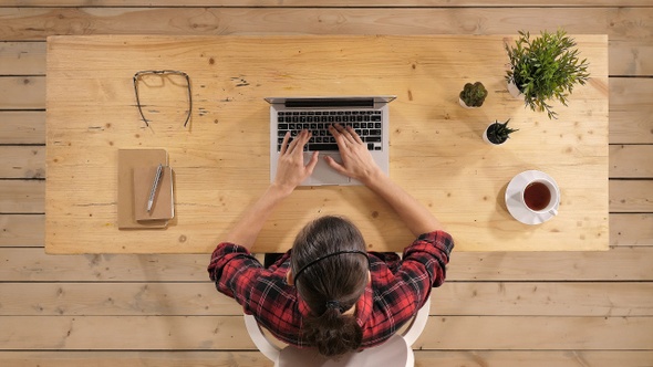 Multitasking woman working on laptop.