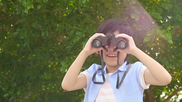 Cute Asian Child Using Binocular On Summer Day