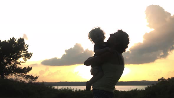 Silhouette of a Mother and Son Sharing a Heartfelt Hug, Outdoors