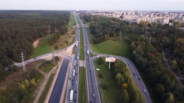 Drone ascending with the view of Kaunas city residential district over the A1 highway with heavy tra