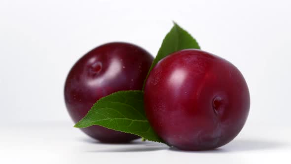 Plums rotating on white background