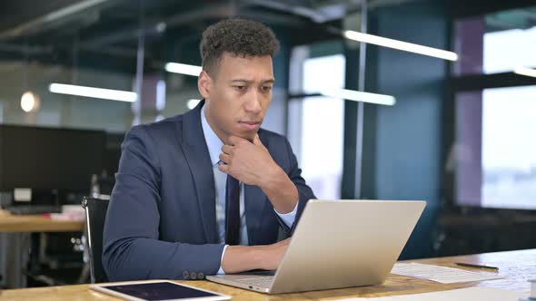 Young Businessman Thinking and Working on Laptop 