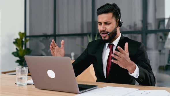 Positive Successful Indian or Arabian Man in Suit with Headset Business Advisor Call Center Worker