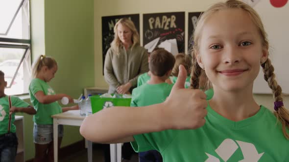 Girl wearing recycle symbol tshirt showing thumbs up alt