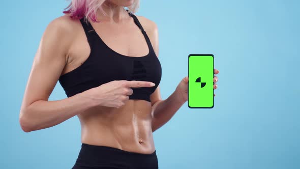 Muscular Woman Bodybuilder Shows on the Screen Phone Mockup